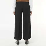 Pantalón de punto color negro, con diseño amplio y textura arrugada, corte holgado y puños ajustados en los tobillos.
