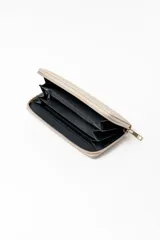 Billetera grande de cuero sintético en color beige, con diseño acolchado de costuras en rombos y cierre perimetral con tirador metálico dorado.