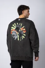 Buzo de cuello redondo y corte oversize, confeccionado en tela friza con efecto de teñido artesanal desgastado. Presenta un estampado pequeño en color verde lima en el pecho y una etiqueta pequeña en el puño.