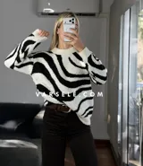 Sweater de tejido de punto con diseño de ondas en color marrón y crema, de cuello redondo y manga larga.