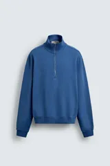 Sudadera de algodón azul con cuello alto y cierre frontal de cremallera de un cuarto. Presenta un corte regular y puños y bajo en rib.