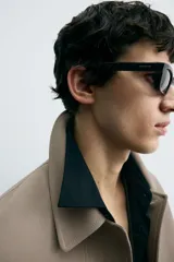 Sobrecamisa color beige de corte cuadrado, con cuello solapa, manga larga con puños abotonados, bolsillos laterales y cierre frontal con botones.