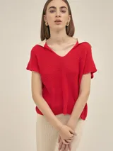 Top tejido rojo de manga corta con cuello camisero blanco, escote en V y calce holgado.