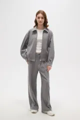 Campera de estilo deportivo en color gris, con cuello solapa, cierre frontal completo y mangas largas con puños ajustados. Presenta un diseño holgado con cintura elástica.