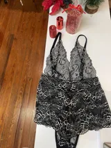 Body entallado de encaje bitono negro con detalles en color hueso, breteles regulables y escote pronunciado. El encaje es suave y elastizado.