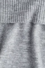 Buzo corto de punto suave color gris, con escote off-the-shoulder con doblez ancho acanalado. Tiene remate acanalado en puños y bajo.