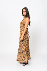 Vestido largo color ocre con estampado floral, escote en V y espalda descubierta.