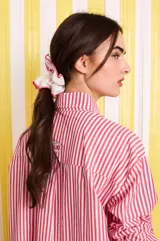 Camisa holgada de popelina de algodón a rayas rojas y blancas, con abertura frontal y detalles de puntilla violeta.