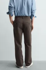 Pantalón chino de corte recto confeccionado en algodón. Presenta bolsillos frontales, un pequeño bolsillo cerillero y bolsillos traseros de vivo con botón. Cierre frontal con cremallera y botón.