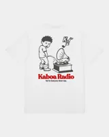 Remera blanca de manga corta con estampado gráfico en la espalda que incluye un personaje ilustrado, un gramófono y la inscripción "Kaboa Radio".