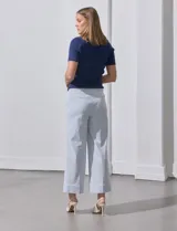 Pantalón wide leg con estampado de rayas verticales celestes y blancas, pretina con botón, bolsillos simulados en la parte delantera y ruedo con dobladillo.