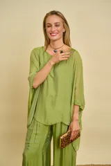 Blusa verde de manga larga con diseño amplio y fluido.