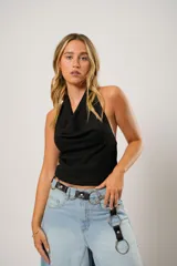 Top negro de cuello volcado y diseño sin mangas, confeccionado en tela de punto con textura suave y ajuste al cuerpo.