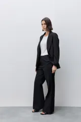 Pantalón de vestir tiro alto wide leg negro, con silueta amplia, bolsillos laterales funcionales y bolsillos traseros de vivo, confeccionado en algodón.