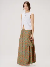 Falda midi de tiro alto y silueta evasé, confeccionada en algodón con diseño estampado geométrico en tonos verdes, naranjas y celestes. Cuenta con caída fluida, ruedo ligeramente acampanado y dos bolsillos cuadrados laterales.