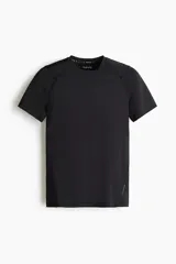 Remera deportiva de compresión color negro, con cuello redondo, mangas raglán cortas y costuras planas antifricción.