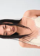 Top de satén color crema con escote en V y detalle de puntilla en el borde inferior. Presenta breteles finos y un corte fluido.