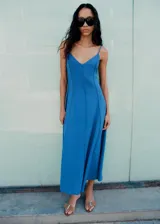 Vestido midi de tirantes finos y escote en V, color azul, con costuras decorativas verticales que realzan la silueta evasé.