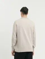 Remera de punto canalé francés con cuello polo, manga larga y cierre frontal de metal con tirador personalizado.