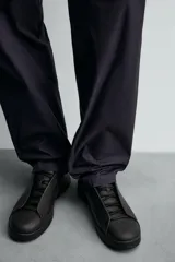 Zapatilla de estilo minimalista confeccionada en piel, con diseño de cordones ocultos, horma redonda y suela a tono.
