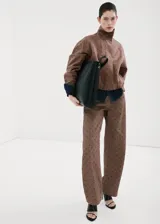 Chaqueta bomber de algodón color marrón con estampado de lunares, cuello embudo, manga larga, bolsillos laterales y cierre oculto con cremallera y botones a presión.
