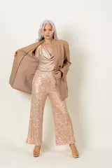 Blazer color beige de crepe de lana, con doble fila de botones negros.