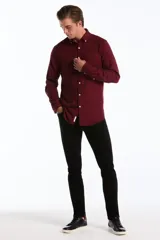 Pantalón de jean negro de corte slim fit, con diseño clásico de cinco bolsillos, presillas para cinturón y cierre frontal con botón y cremallera.