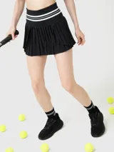 Falda tipo skort con diseño plisado y cintura alta elástica con detalles de rayas blancas. Incluye short integrado con bolsillo, confeccionada en tejido técnico de secado rápido.