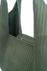 Bolso tipo tote bag de tela color verde oliva con textura acanalada.