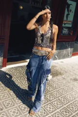 Pantalón cargo oversize de jean, con múltiples bolsillos funcionales y detalles metálicos.