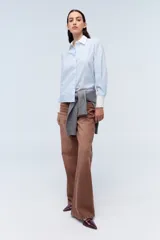 Camisa celeste a rayas con cuello clásico y puños blancos con volados.