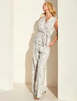 Pantalón palazzo de tiro alto con estampa floral azul sobre base beige, corte de pierna ancha, cintura elastizada con cordón de ajuste y bolsillos laterales.