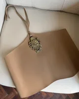 Top halter marrón de ecocuero, con escote recto y tiras ajustables en la espalda. Presenta una aplicación metálica dorada en el centro del pecho con el escudo de Uruguay.