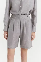 Bermuda de lino color gris con calce recto y diseño sastrero. Cuenta con cintura con pinzas, bolsillos frontales de estilo americano y cierre con botones ocultos.