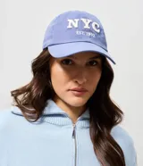 Gorra de sarga color azul con visera curva y estampa bordada con el texto NYC EST. 1992 en color blanco.