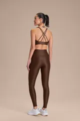 Top deportivo de compresión media con diseño de espalda cruzada y breteles finos. Confeccionado en tejido acanalado con un acabado de brillo sutil, cuenta con copas removibles y tecnología de ajuste adaptable.