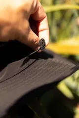 Sombrero negro tipo pescador con ala ancha, cordón ajustable naranja y parche frontal con logo de la marca Denali.