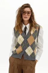Chaleco de punto color gris con estampado de rombos (argyle) en beige y verde lima. Tiene escote en V, botones frontales y terminaciones de rib.