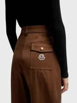 Pantalón de corte recto con cintura alta, cierre frontal con botón y costuras verticales decorativas en el frente.