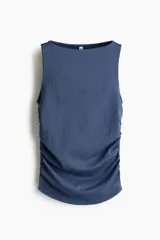 Top sin mangas de punto elástico texturizado en color azul, con escote bote y frunces en los laterales que crean un efecto drapeado.