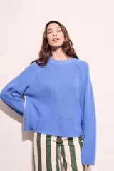Sweater de algodón color azul, de punto grueso, con cuello redondo y mangas largas.