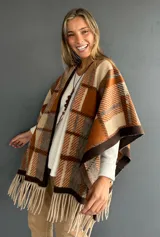 Ruana abierta con diseño de cuadros en tonos tierra, naranja y beige, con terminación de flecos en el ruedo.