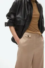 Pantalón sastrero de tiro alto con corte recto, confeccionado con pretina prolongada, cierre frontal, bolsillos laterales y detalle de bolsillo monedero con solapa en la cintura.