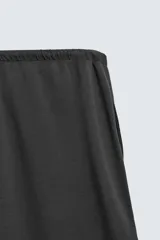 Pantalón de corte baggy fit confeccionado en tejido técnico, con cintura elástica ajustable mediante cordón y bajo con elásticos laterales para ajuste.