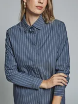 Camisa azul con rayas verticales blancas, de corte clásico, con cuello camisero y mangas largas.