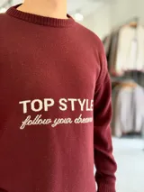 Sweater de punto color beige con cuello redondo, manga larga y diseño estampado en el pecho con las frases "TOP STYLE" y "follow your dreams" en color marrón.