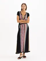 Vestido largo de punto negro con diseño jacquard multicolor en el frente y la espalda, mangas cortas y escote redondo con cordones entrecruzados.