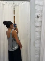 Musculosa negra con acabado satinado y sutil brillo, de corte holgado y diseño básico con breteles anchos.