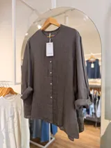 Camisa de lino gris oscuro con cuello mao, cierre frontal de botones y mangas largas remangadas.