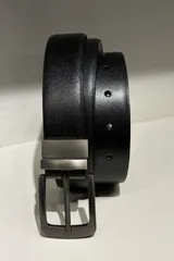 Cinto reversible para hombre, con una cara negra y otra color chocolate, fabricado en cuero con hebilla metálica de diseño clásico.